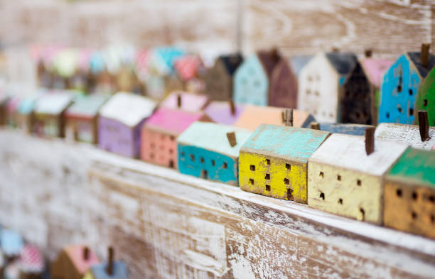 Small handmade wooden houses in a row on store shelf. Craft, home decor concept. Scandinavian, country style stock photo