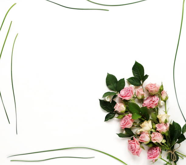 istock Frame with pink roses bouquet, green leaves on white background. 892571140