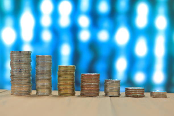 istock Coin tower stacked in decline chart digital bokeh light in the background 892577796