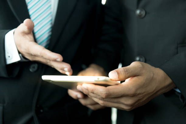 istock Businessmen wear a suit in a modern office using a tablet to study a projector, a businessman uses a tablet in a modern office. 892599458