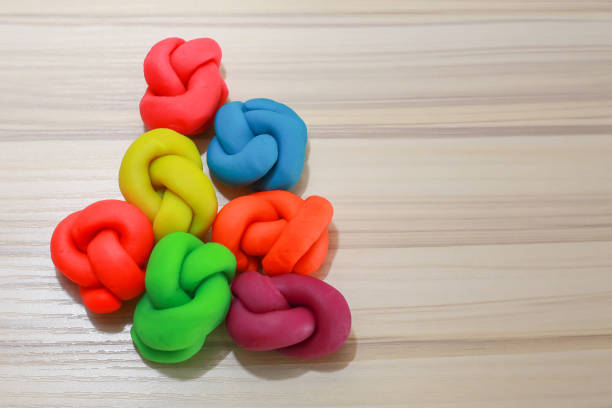 istock colorful playdough close up image on wooden table. 892599562