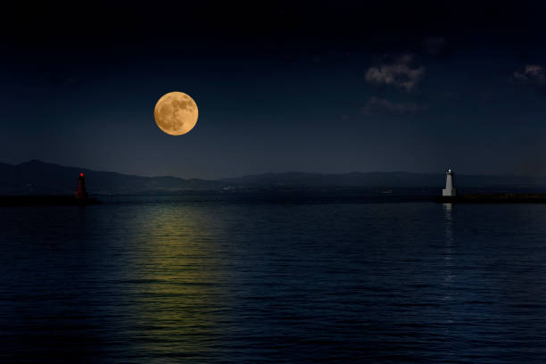 istock Full moon rising over the sea and the lighthouse 892603998