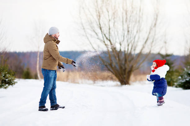 istock Father and daughter at snowy park. 892622804