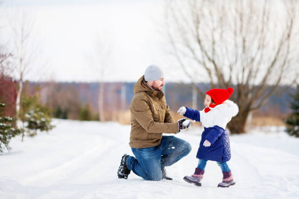 istock Father and daughter at snowy park. 892624850