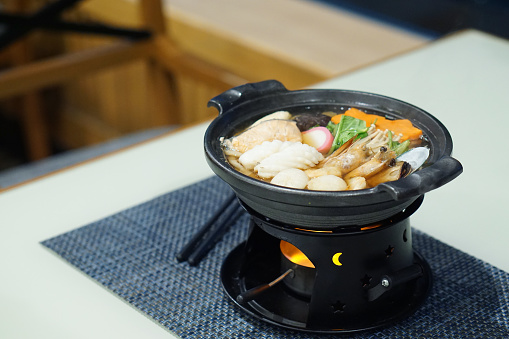 Hot pot (nabe) seafood with salmon, shrimp, squid, mussel and vegetable, Japanese traditional food.