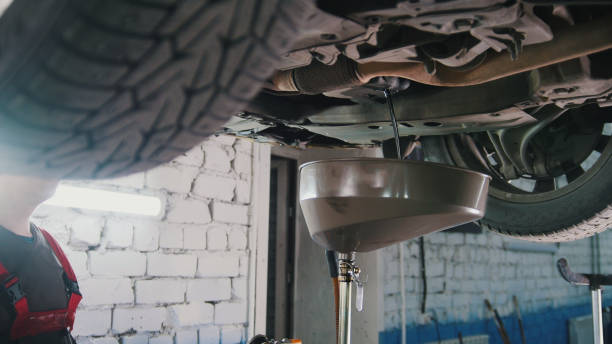 istock Engine oil under bottom of the car in garage workshop, close up 892634226