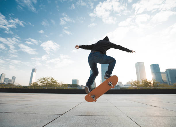 istock female skateboarder jumping on city with skateboard 892643534