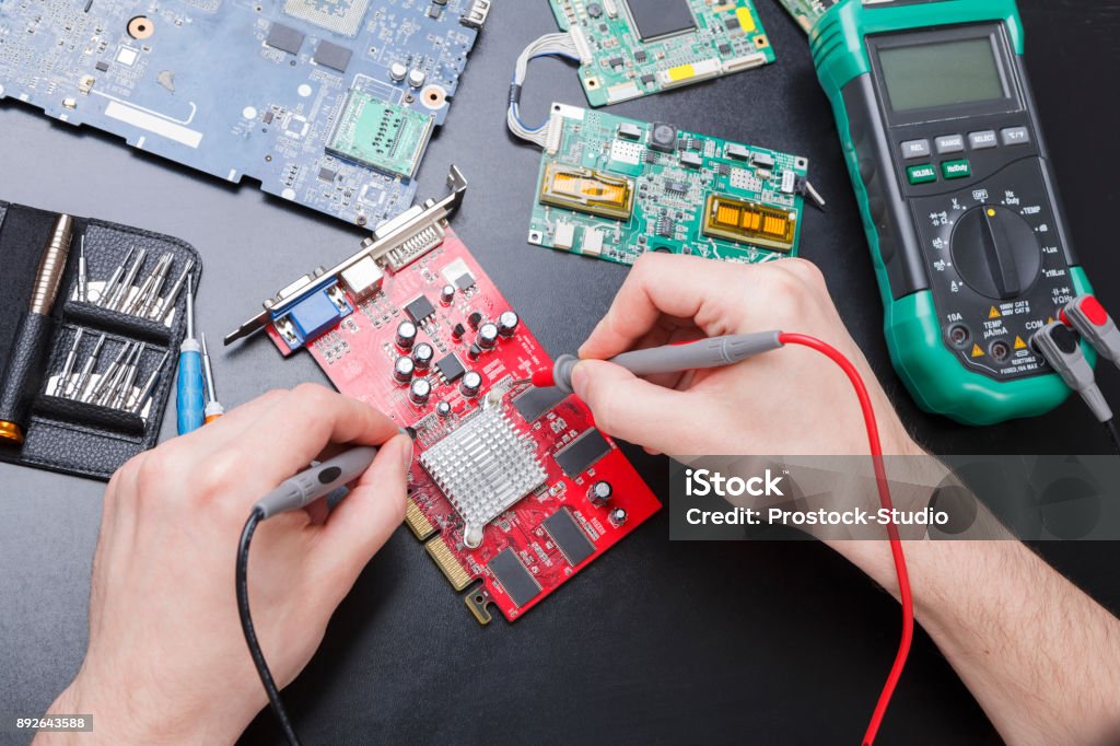 Electronic circuit red board inspecting close up Electronic circuit red board inspecting close up. Engineer measuring computer component, maintenance support and repairing service concept, top view Electrical Equipment Stock Photo