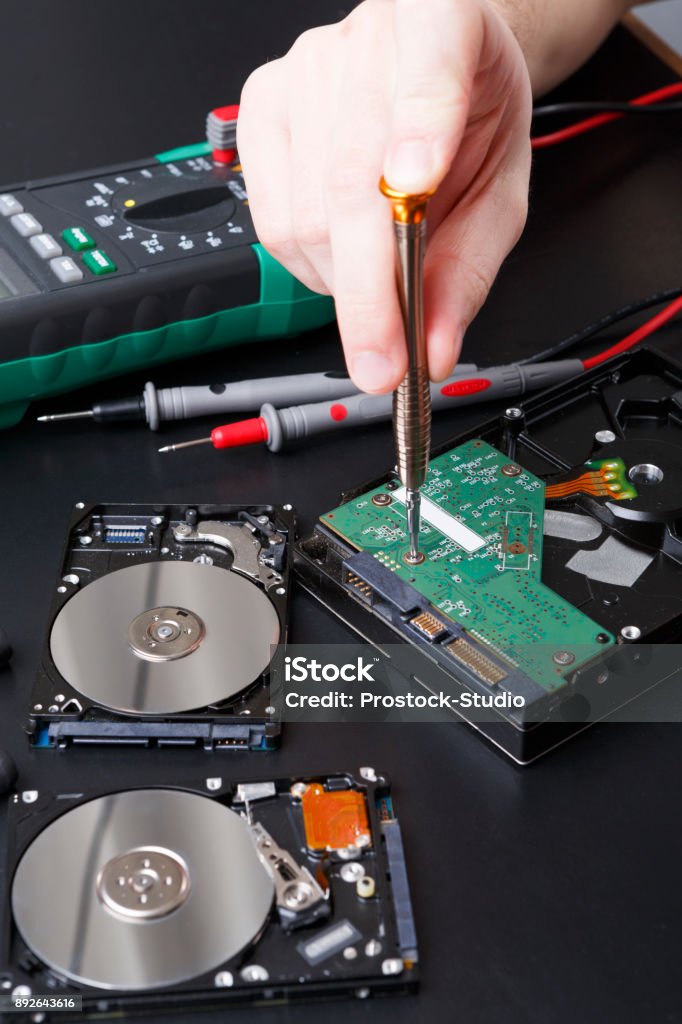 Hard disc drive disassembling close up Hard disc drive disassembling close up. Repairman opening hdd for recovery information, service center and electronics repair concept. Electronics Industry Stock Photo