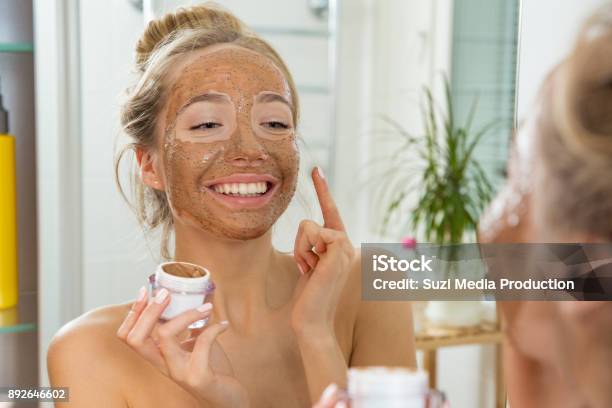 Young Beautiful Girl Applying Facial Scrub Mask On Skin Stock Photo - Download Image Now