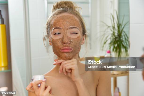 Young Beautiful Girl Applying Facial Scrub Mask On Skin Stock Photo - Download Image Now