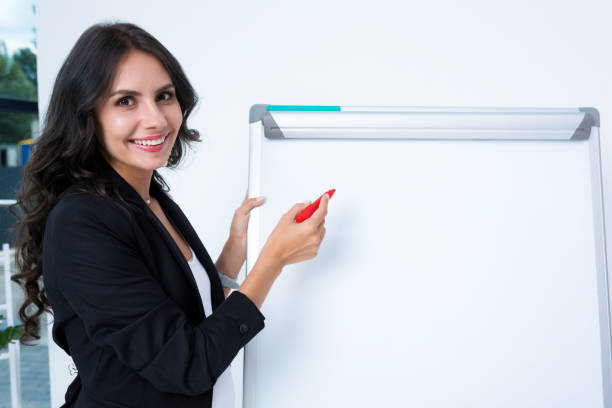 istock pregnant businesswoman writing on whiteboard 892646982