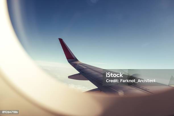 An Airplane Wing Through Airplane Window With Blue Sky Background Stock Photo - Download Image Now