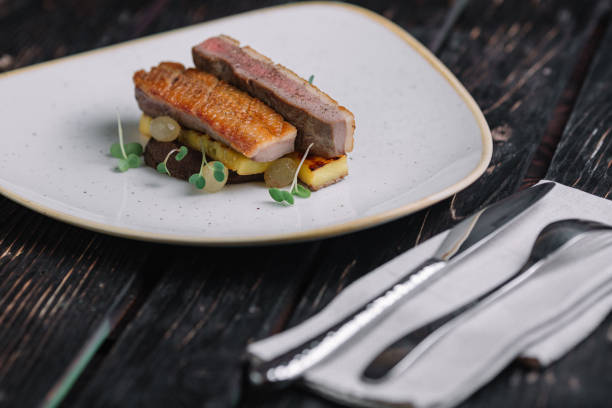 istock Duck fillet with polenta on irregular shape plate on dark wood background 892658168