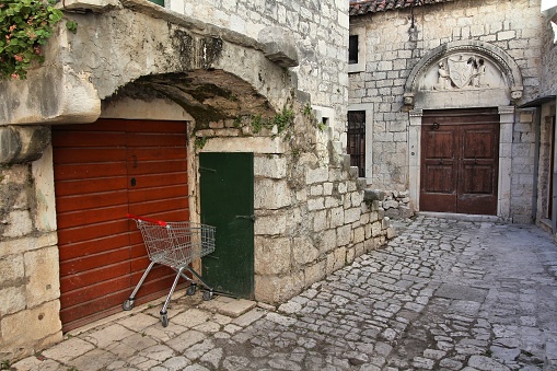 Traditional arch wooden door and window painted green , stone house, rooftop seen from the street. Castrillo de los Polvazares, León, Castilla y León, Spain.