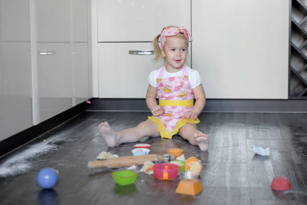 Little girl is cooking on kitchen. Having fun while making cakes and cookies