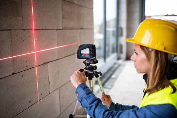 istock Young woman worker with laser on the building site. 892679552