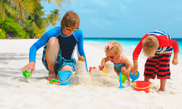 istock father with son and daughter play on beach 892694052
