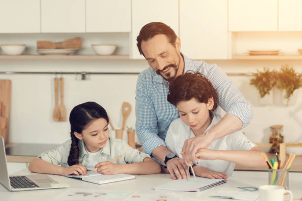 istock Positive handsome man standing behind his son 892694298