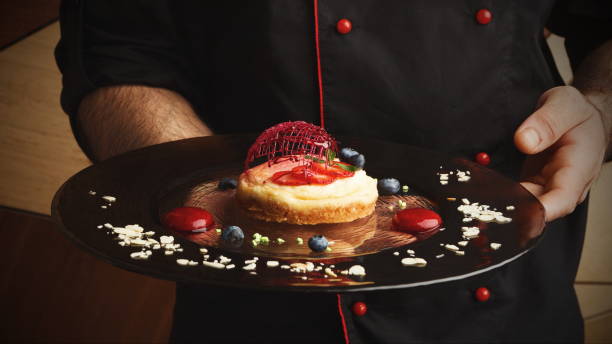 istock Lemon cheesecake with berry spheres served at modern restaurant 892701162
