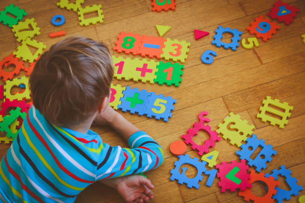 istock little boy playing with puzzle, education concept 892701908