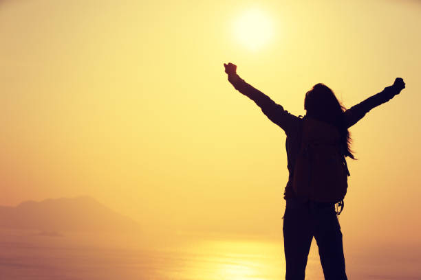 istock free female hiker with backpack standing on sunrise windy coast 892706538