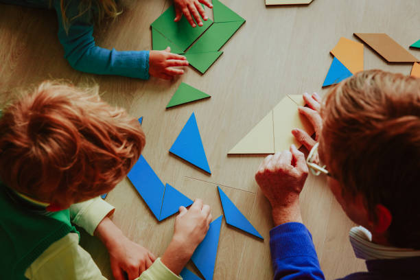 istock teacher and kids playing with geometric shapes 892706582