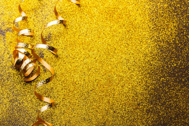 istock Curly golden serpentine on glitter background 892711568