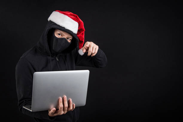 mysterious male santa hacker holding laptop computer