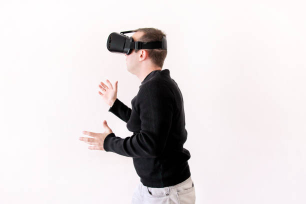 istock Handsome man wearing and playing virtual reality on isolated white background. Boy action in virtual reality helmet. VR glasses. VR Box, VR headset. Young business man at office and using Vr Box. 892726522