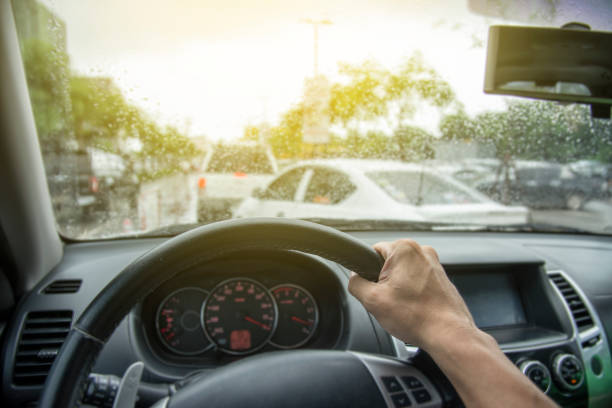 Traffic jam in the rush hour.Hand of a man driving car with traffic jam in rainy seasons.Rainy weather in road traffic. Risk of accident during rainy seasons stock photo