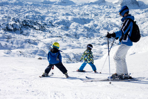 istock Father and two boys, skiing on a sunny day on a mountain summit in Austria resort 892736698