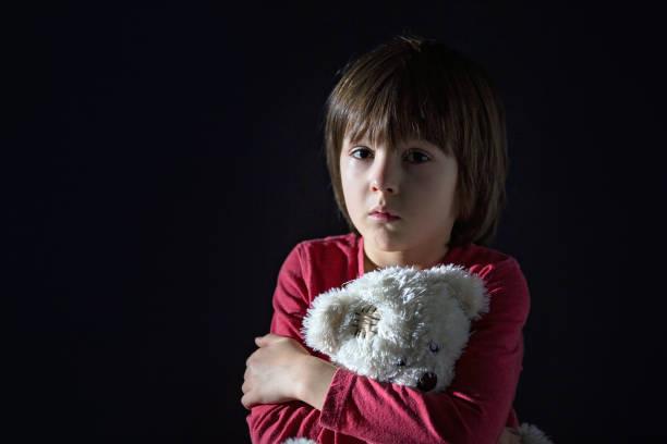 istock Sad little child, crying, hugging stuffed toy 892739130