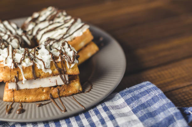 istock waffles with cream and chocolate on plate on wooden table 892739496