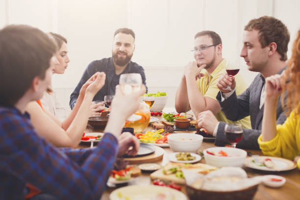 istock Group of happy people at festive table dinner party 892743434