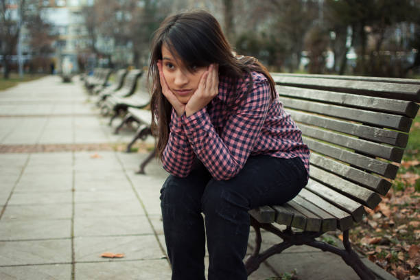 istock Sad woman in a park bench 892748236