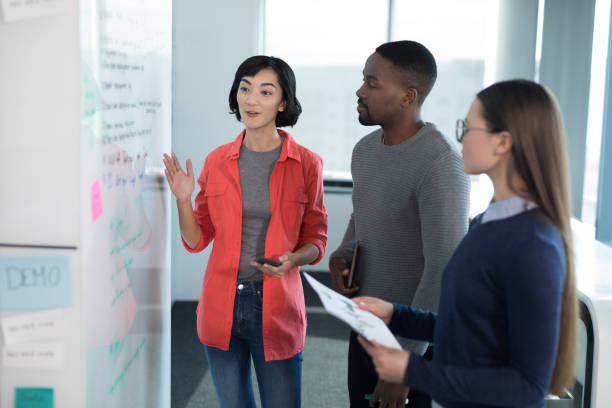 istock Male and female executives discussing on whiteboard 892748522