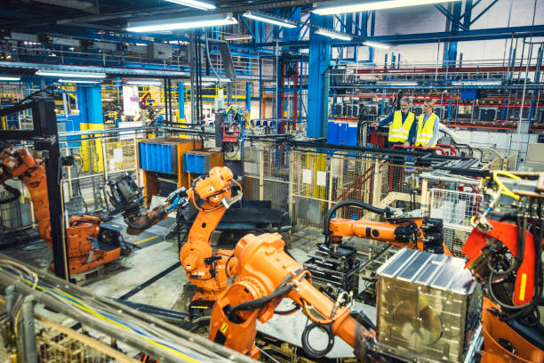 istock Male and female engineer looking at robotic arms 892766274