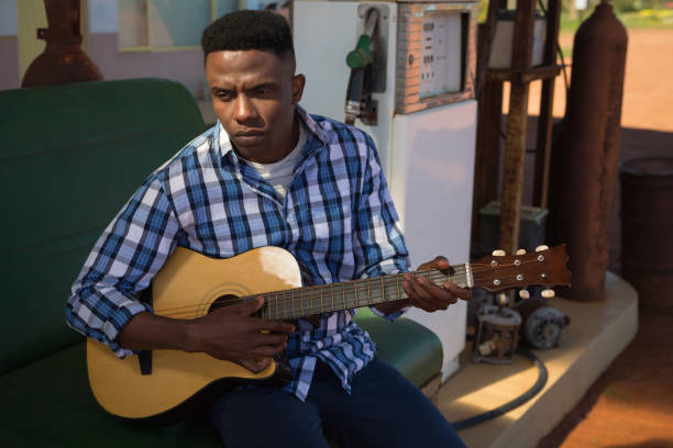 istock Man playing guitar at petrol pump station 892770710