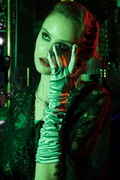 istock woman's portrait in green light and hands next to face and eyes 892771098