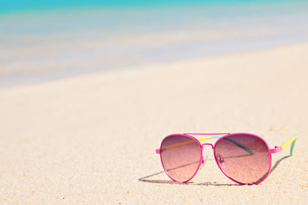 istock Pink sunglasses on sandy tropical beach in summer 892771240