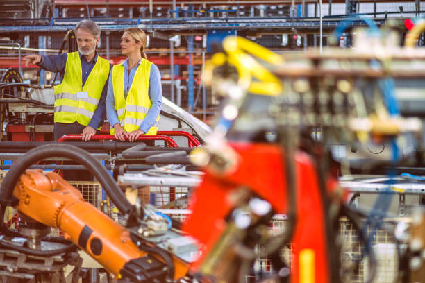 istock Engineer showing something to young factory manager 892771530