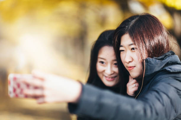 istock Two Female Friends Taking Selfie In Autumn 892776238