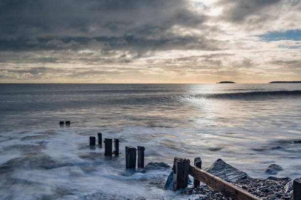 istock Beach on a winters day, with the sun breaking through 892779230