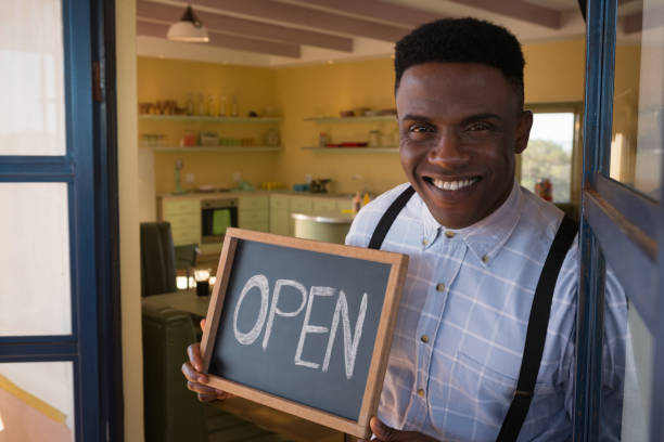 istock Male owner holding chalkboard with open sign 892780458
