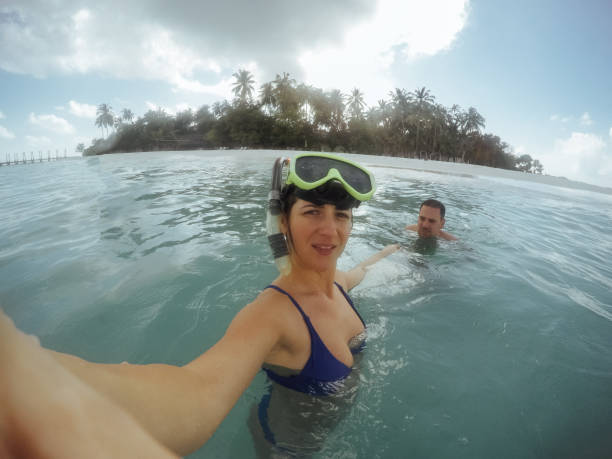istock Young couple taking selfie before diving into blue sea water 892791016