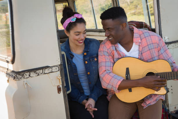 istock Man playing guitar for woman at countryside 892797042