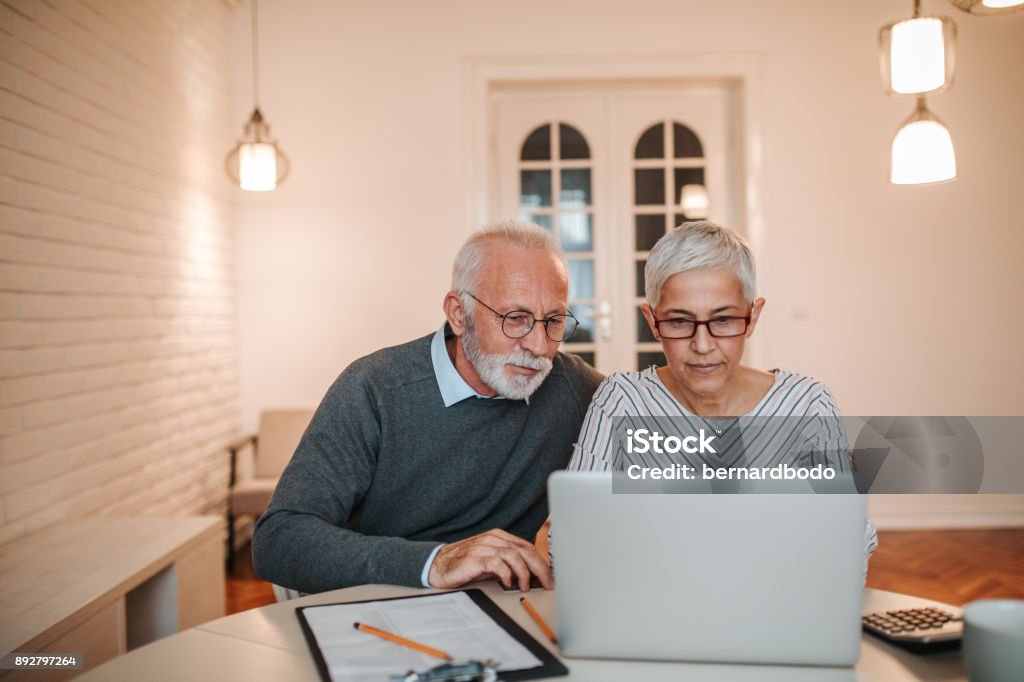 Time to go over the budget Senior couple browsing the internet together Senior Couple Stock Photo