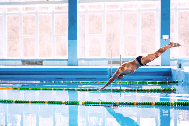 istock Senior man jumping in the swimming pool. 892797274