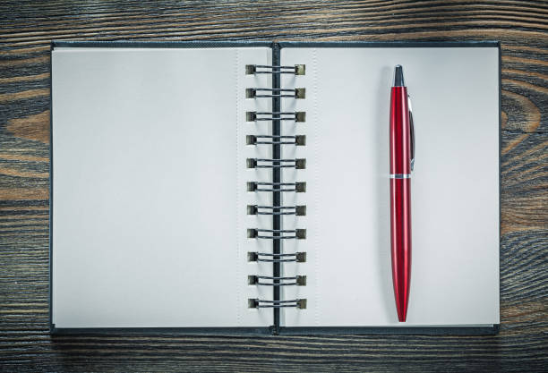istock Blank spiral notebook pen on vintage wooden board 892800746